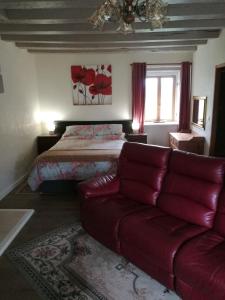 a living room with a couch and a bed at Chez Pastuso in Brigueuil-le-Chantre