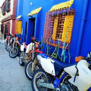 una fila de motocicletas estacionadas frente a un edificio azul en Atlas Room en Midelt