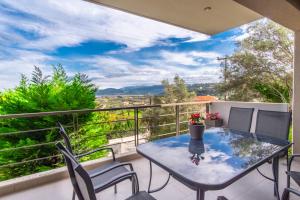 a table and chairs on a balcony with a view at PANORAMA APARTMENT in Apolpaina