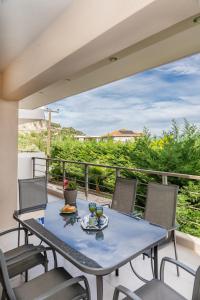 a blue table and chairs on a balcony at PANORAMA APARTMENT in Apolpaina