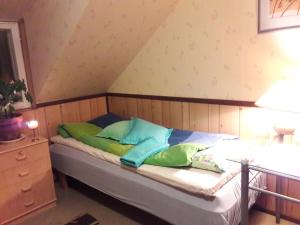 a bed with green and blue pillows in a room at Huoneisto omenapuiden katveessa in Kankaanpää