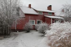a red house with snow on top of it at Huoneisto omenapuiden katveessa in Kankaanpää