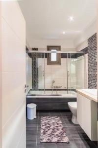 a bathroom with a tub and a toilet and a sink at PANORAMA APARTMENT in Apolpaina +18 photos