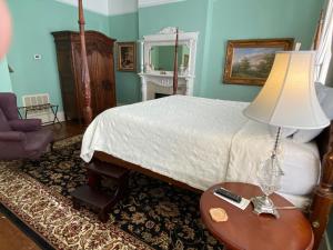 1 dormitorio con 1 cama y 1 mesa con lámpara en Foley House Inn, en Savannah