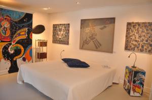 een slaapkamer met een wit bed en schilderijen aan de muur bij Exklusive Ferienwohnung in Außervillgraten