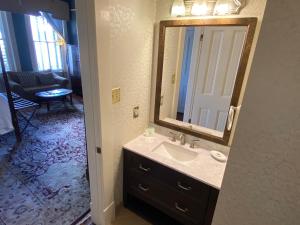 a bathroom with a sink and a large mirror at Foley House Inn in Savannah