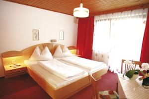 ein Schlafzimmer mit einem großen Bett mit weißer Bettwäsche in der Unterkunft Frühstückspension Anna Maria in Sankt Kanzian am Klopeiner See
