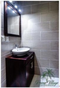 een badkamer met een wastafel en een spiegel bij PRIME VILLAGE Cozumel in Cozumel