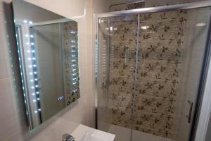 a bathroom with a shower and a sink and a mirror at Eagle Hotel Luton Airport in Luton