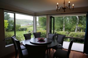 a dining room with a table and chairs and large windows at Star Dream Manor in Lake Tekapo