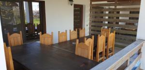 a wooden table and chairs in a room at Casa de vacanta Spiritul Deltei in Sfântu Gheorghe