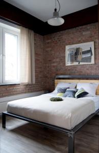 um quarto com uma cama grande e uma parede de tijolos em Apartamenty Folwark Boguszyn em Kłodzko
