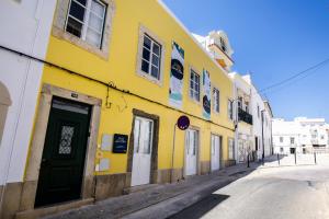 a yellow building on the side of a street at Faro Downtown Ria Formosa Studios in Faro