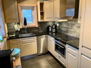 a kitchen with white cabinets and a sink at Ferienhaus Stenbäcken in Mittelschweden in Töcksfors