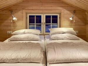 a room with three beds and a window at Ferienhaus Stenbäcken in Mittelschweden in Töcksfors