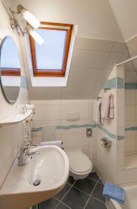 a bathroom with a sink and a toilet and a window at Pension Kühns Mühle in Oestrich-Winkel