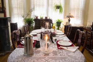 a dining room table with a table cloth with a candle at Magnolia House Inn in Hampton