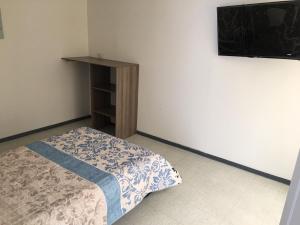 a bedroom with a bed and a tv on a wall at Estadía El Dorado in Bogotá
