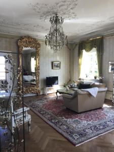 sala de estar con sofá y espejo en Gamla Stan Simrishamn, en Simrishamn