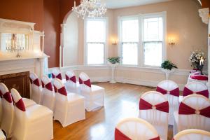 una stanza con sedie bianche, tavolo e lampadario a braccio di Magnolia House Inn a Hampton
