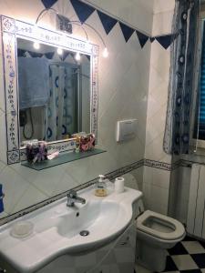 a bathroom with a sink and a mirror and a toilet at APPARTAMENTO GABBRO-ROSIGNANO MARITTIMO in Gabbro +15 photos