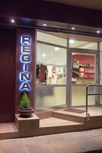 ブラナスにあるHostal Reginaの看板と植物を前に置いた店舗