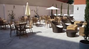 a restaurant with tables and chairs and a umbrella at Eco Alcalá Suites in Madrid