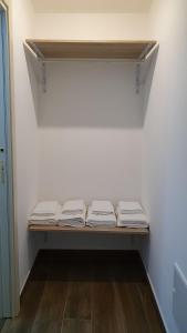 uma prateleira com três cobertores dobrados em uma sala em DOMU NOSTA di Giulio & Ignazia Room1 em Santa Luria