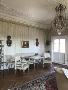 un soggiorno con divano, sedie e lampadario pendente di Gamla Stan Simrishamn a Simrishamn