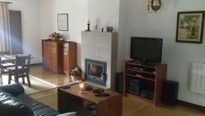 a living room with a couch and a tv at Casa Maria Joana in Ponte de Lima