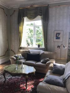 uma sala de estar com sofás, uma mesa e uma janela em Gamla Stan Simrishamn em Simrishamn