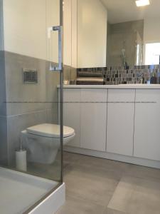 a bathroom with a toilet and a sink at Apartament45 in Giżycko