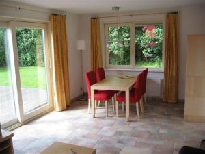 uma sala de jantar com uma mesa e cadeiras vermelhas em Koperwiek Texel em Den Burg
