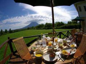 a table with food and an umbrella on a patio at Hotel Resort Inn Niseko in Niseko