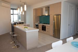 a kitchen with a counter and a refrigerator at Vue Apartments in Napier