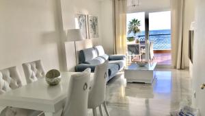 a living room with a white table and chairs at MI CAPRICHO A17 Beachfront Apartment in La Cala de Mijas