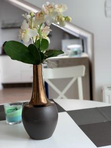 a vase with flowers in it sitting on a table at Apartament45 in Giżycko