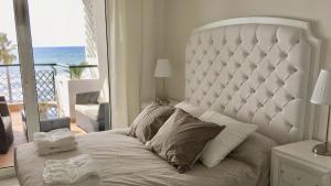a bedroom with a large white bed with a view of the ocean at MI CAPRICHO A17 Beachfront Apartment in La Cala de Mijas +38 photos