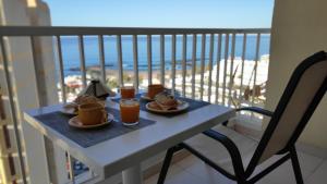 una mesa con comida y bebida en el balcón en Apartamento Playa las Americas, en Playa de las Américas