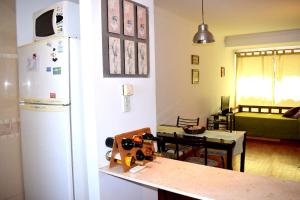 cocina con nevera blanca y mesa con herramientas en Departamento Salta mi Ciudad 1, en Salta