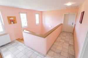 ein Zimmer mit rosa Wänden und einem Flur mit einer Treppe in der Unterkunft Studio Apartment Lehen 2 in Wien