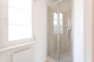 uma cabina de duche em vidro numa casa de banho com uma janela em Studio Apartment Lehen 2 em Viena