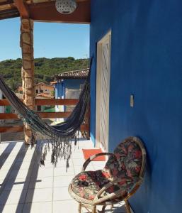 uma rede de descanso numa varanda com uma parede azul em Pousada Pé na Areia em Pipa