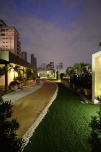 a park with green grass and buildings at night at Beverly 33 by Aspira in Bangkok