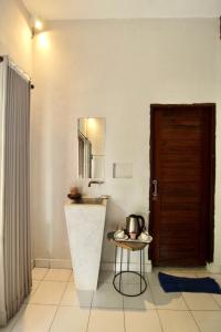 Zimmer mit einer Tür, einem Tisch und einem Spiegel in der Unterkunft Umah Nik Kepitu in Gianyar