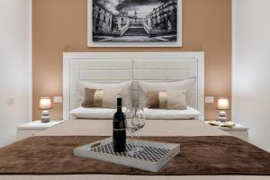 una camera da letto con una bottiglia di vino su un letto di Residenze Chamur Via Volturno a Palermo