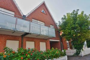 ein rotes Backsteingebäude mit Balkon in der Unterkunft Zentrales Apartment für 2 *Bogenstraße* in Norderney