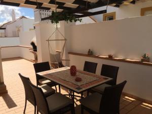 eine Terrasse mit Tisch und Stühlen auf einem Balkon in der Unterkunft Gomeira Top Floor in Cabanas de Tavira