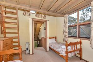 a bedroom with a bunk bed and a staircase at Bidgee Widgee in Dinner Plain