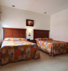 two beds sitting next to each other in a room at Hotel el Mayo Inn in Culiacán +36 photos